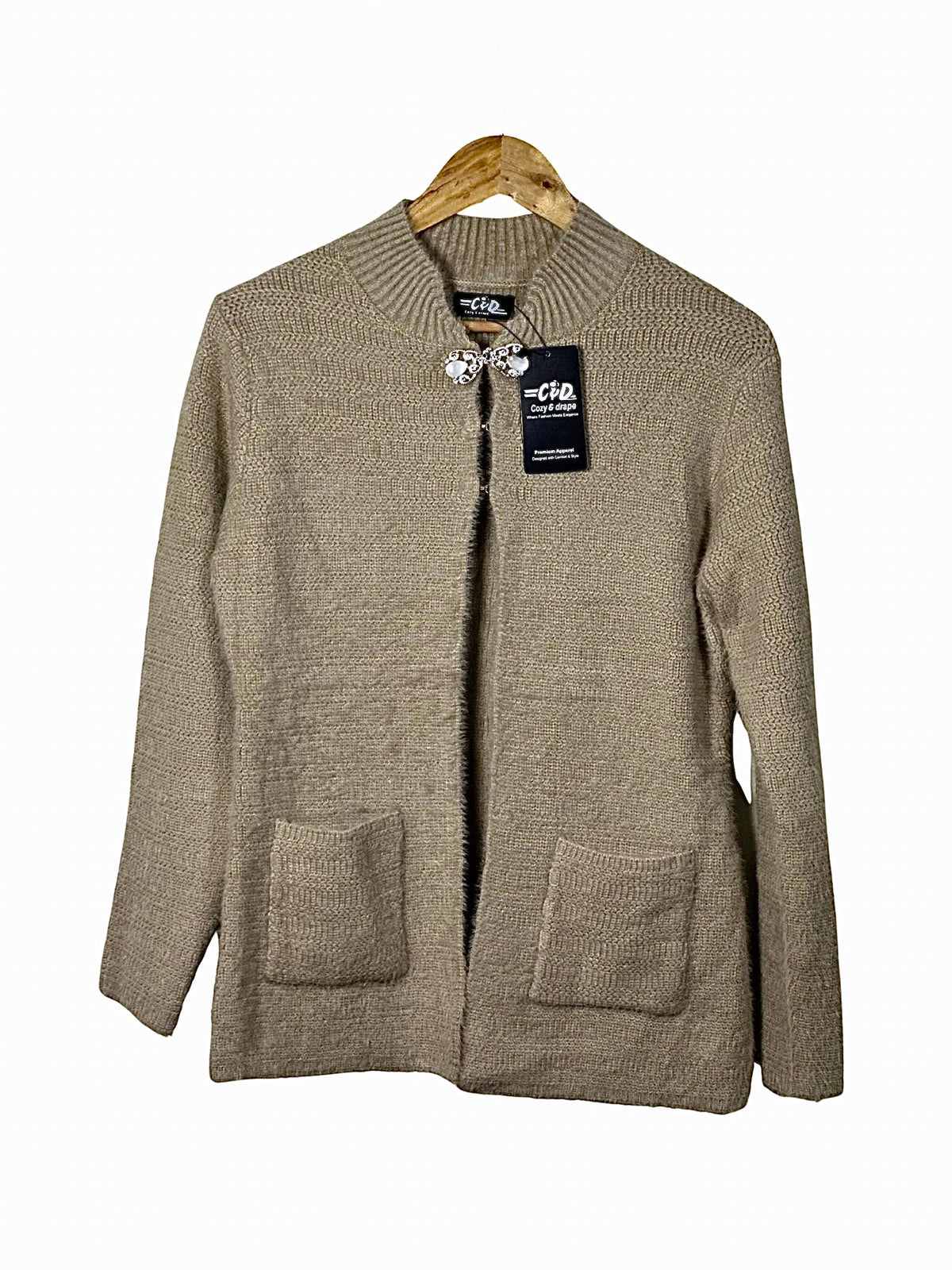 Cozy&Drape beige open-front knit cardigan sweater with long sleeves and two front pockets on a wooden hanger
