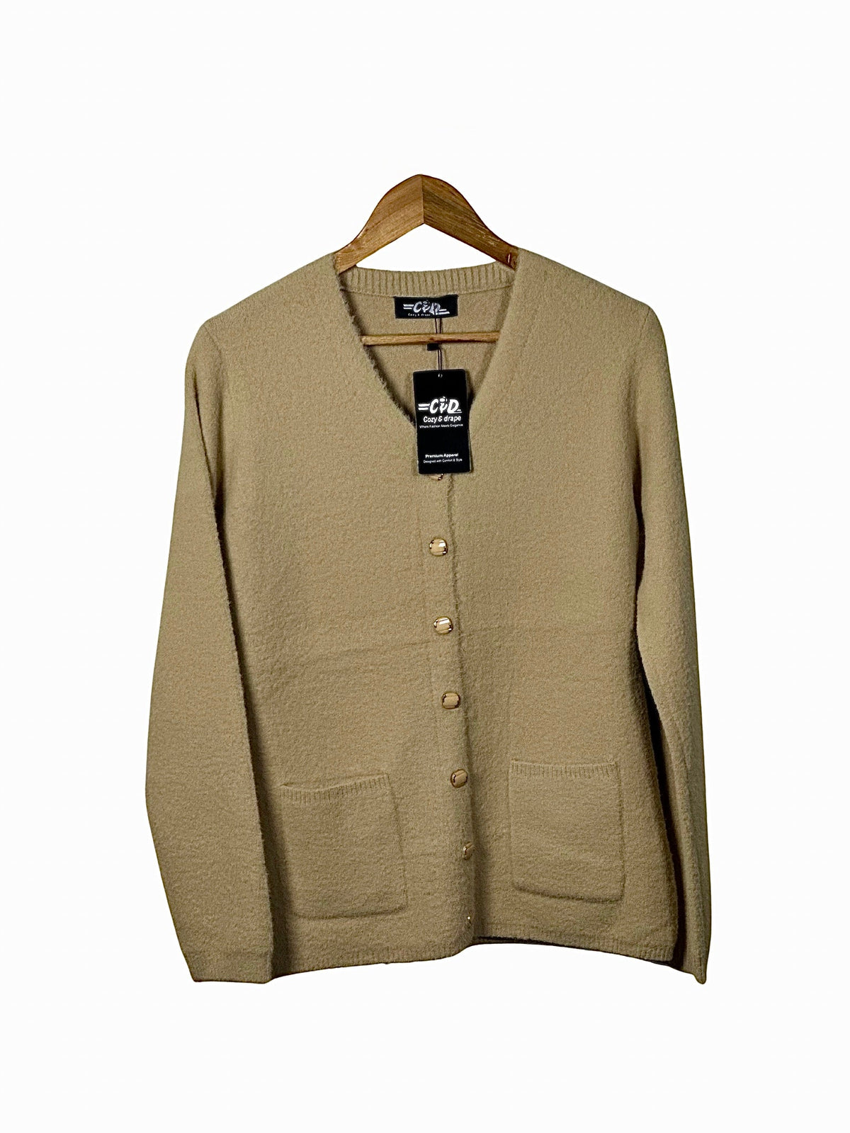 Cozy&Drape beige full sleeve cardigan sweater with a V-neck, button front, and two front pockets on a wooden hanger.
