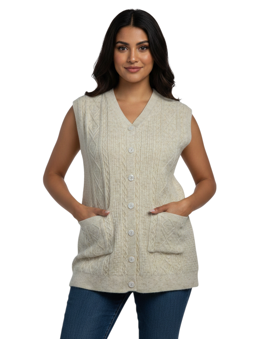 A woman wearing a Cozy&Drape beige cable-knit sleeveless button-up cardigan with front patch pockets and a V-neckline.
