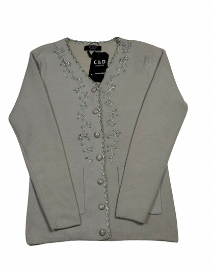 Cozy&Drape beige V-neck knit cardigan with delicate silver floral embroidery along the button placket and front pockets.