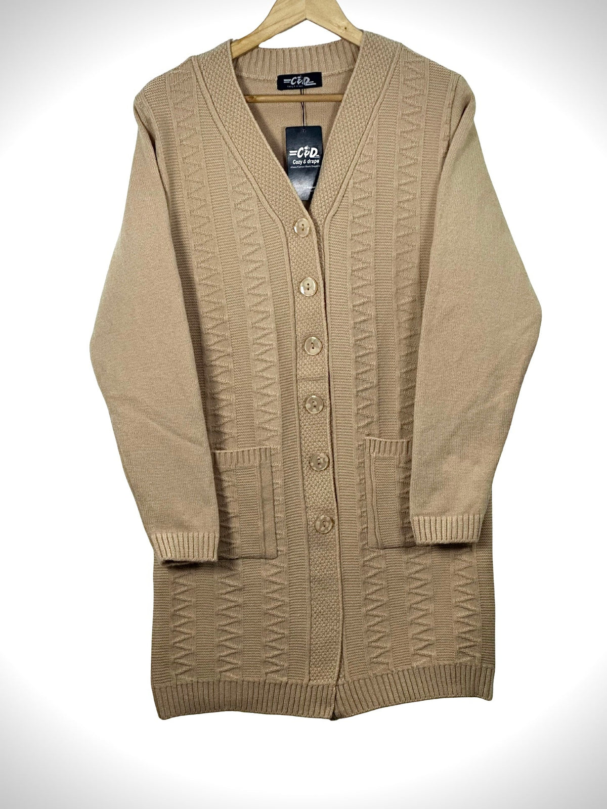 Cozy&Drape beige long-line knit cardigan with V-neck, button-front closure, and two front pockets on a hanger.