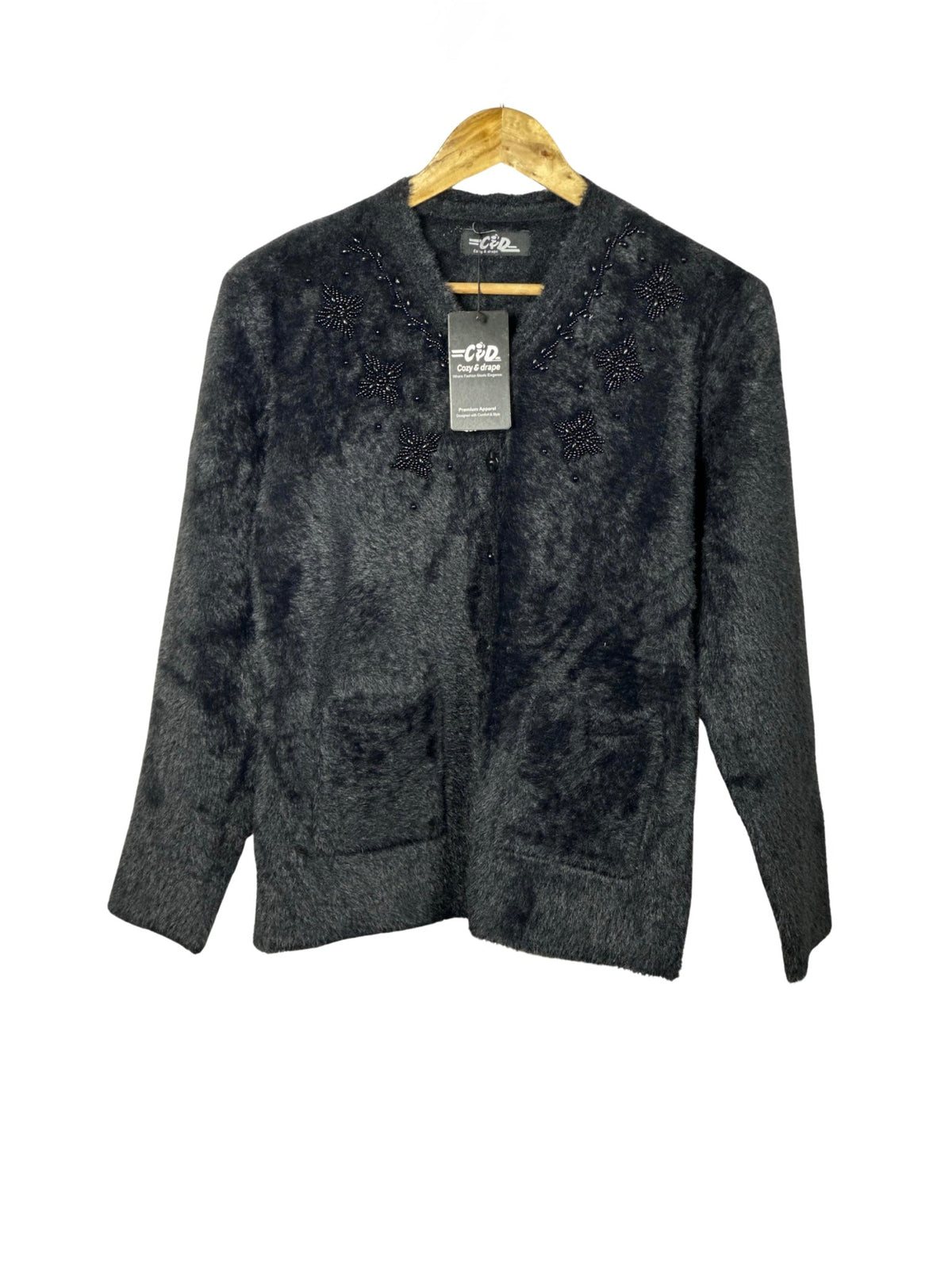 Cozy&Drape black fuzzy knit cardigan sweater with beaded floral embellishments and front pockets on a wooden hanger