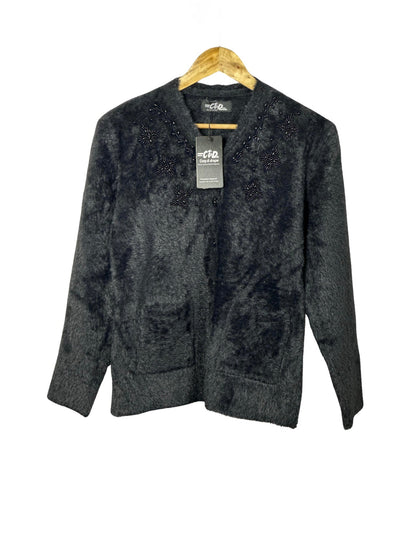 Cozy&Drape black fuzzy knit cardigan sweater with beaded floral embellishments and front pockets on a wooden hanger