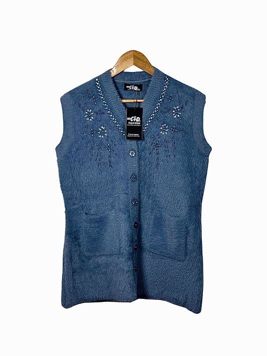 Cozy&Drape blue fuzzy knit sleeveless cardigan vest with V-neck, delicate beadwork, and front pockets on a hanger