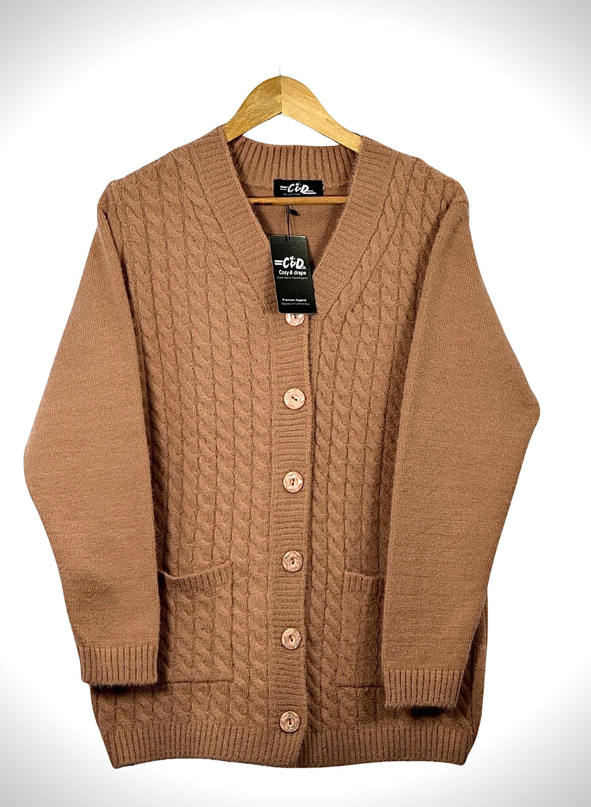 Cozy&Drape brown cable knit cardigan sweater with long sleeves, front buttons, and two pockets on a wooden hanger