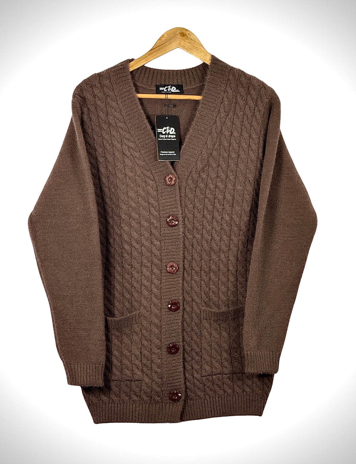 Cozy&Drape brown full sleeve cardigan sweater with a cable knit pattern, front buttons, and two pockets on a hanger.