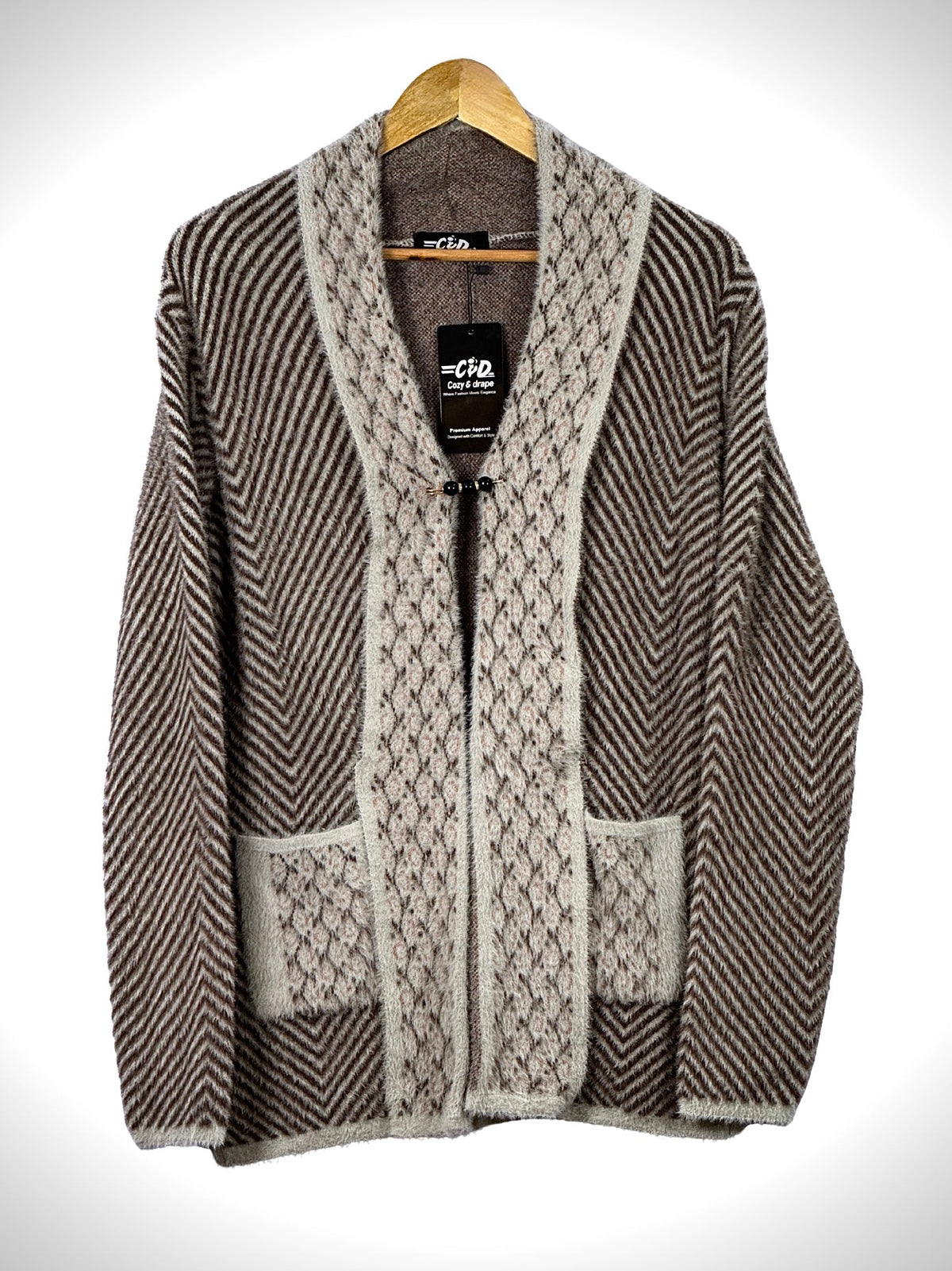 Cozy&Drape brown and beige open front sweater with chevron pattern, textured trim, and two front pockets on a hanger