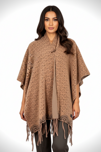 Model wearing a Cozy&Drape brown geometric patterned poncho wrap with fringe hem and decorative neckline closure