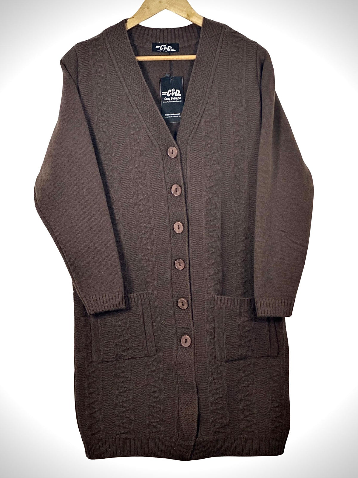 Cozy&Drape long-line brown knit cardigan with V-neck, button-front closure, and two front pockets on a wooden hanger.