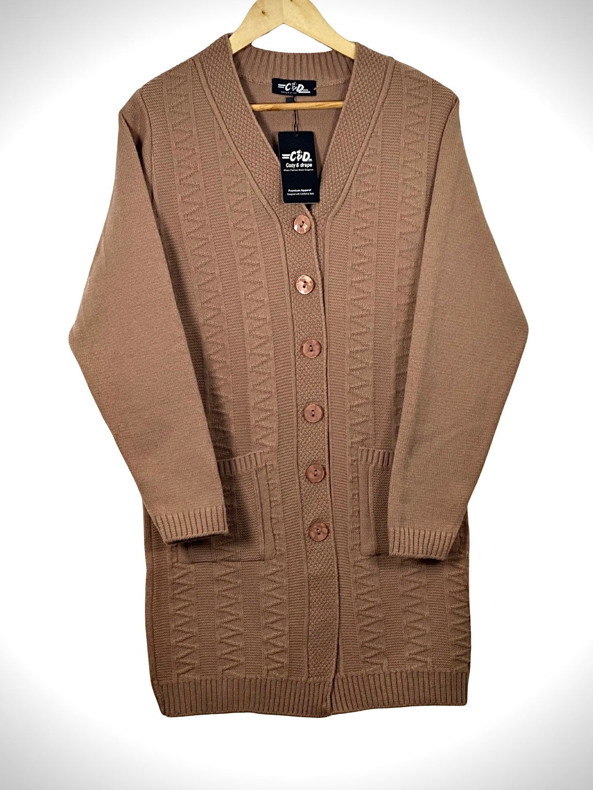 Cozy&Drape long-line tan knit cardigan with V-neck, button front, and two front pockets on a wooden hanger.