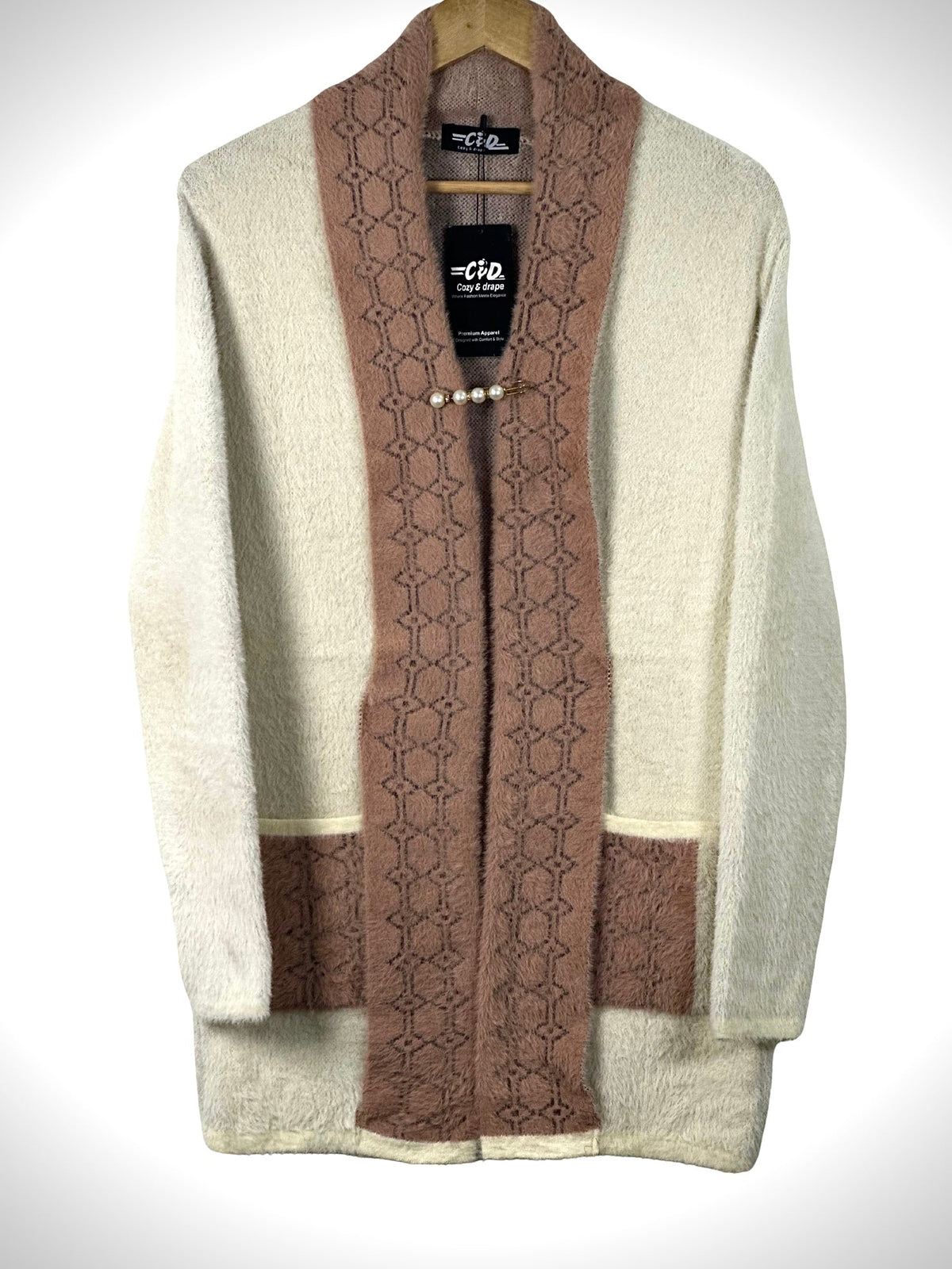 Cozy&Drape open front sweater in cream and mauve with textured geometric trim, front pockets, and pearl pin closure.