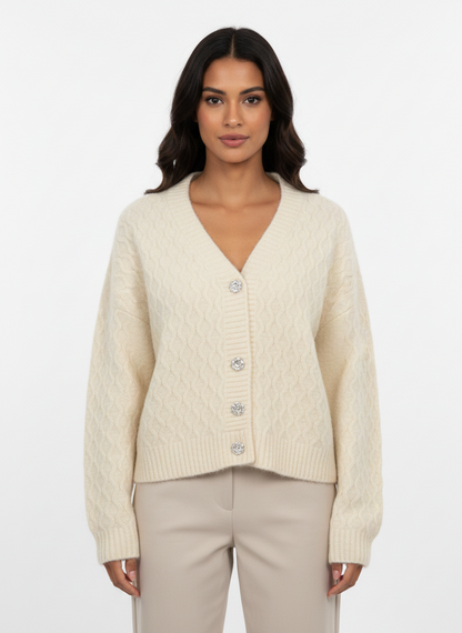 Model wearing a Cozy&Drape cream cable-knit V-neck cardigan with decorative buttons and ribbed trim