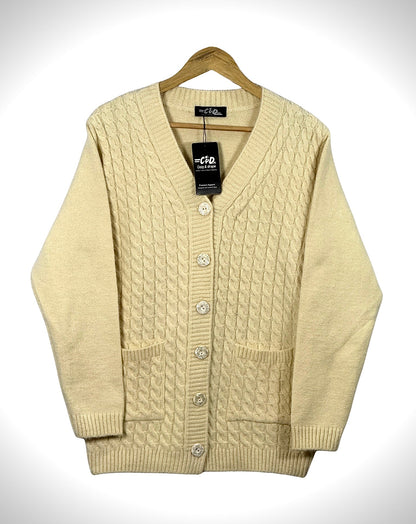 Cozy&Drape cream cable knit cardigan sweater with long sleeves, front buttons, and two pockets on a wooden hanger.
