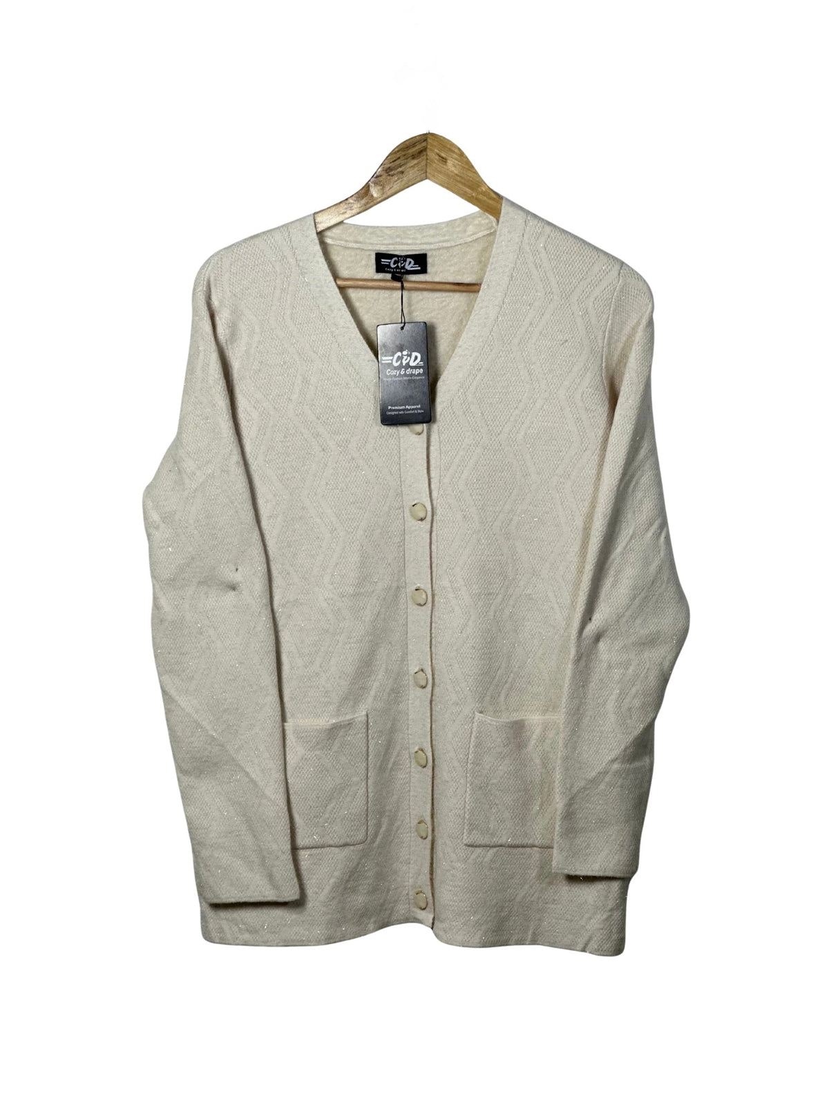 Cozy&Drape cream full sleeve cardigan sweater with front pockets and textured geometric pattern on a wooden hanger