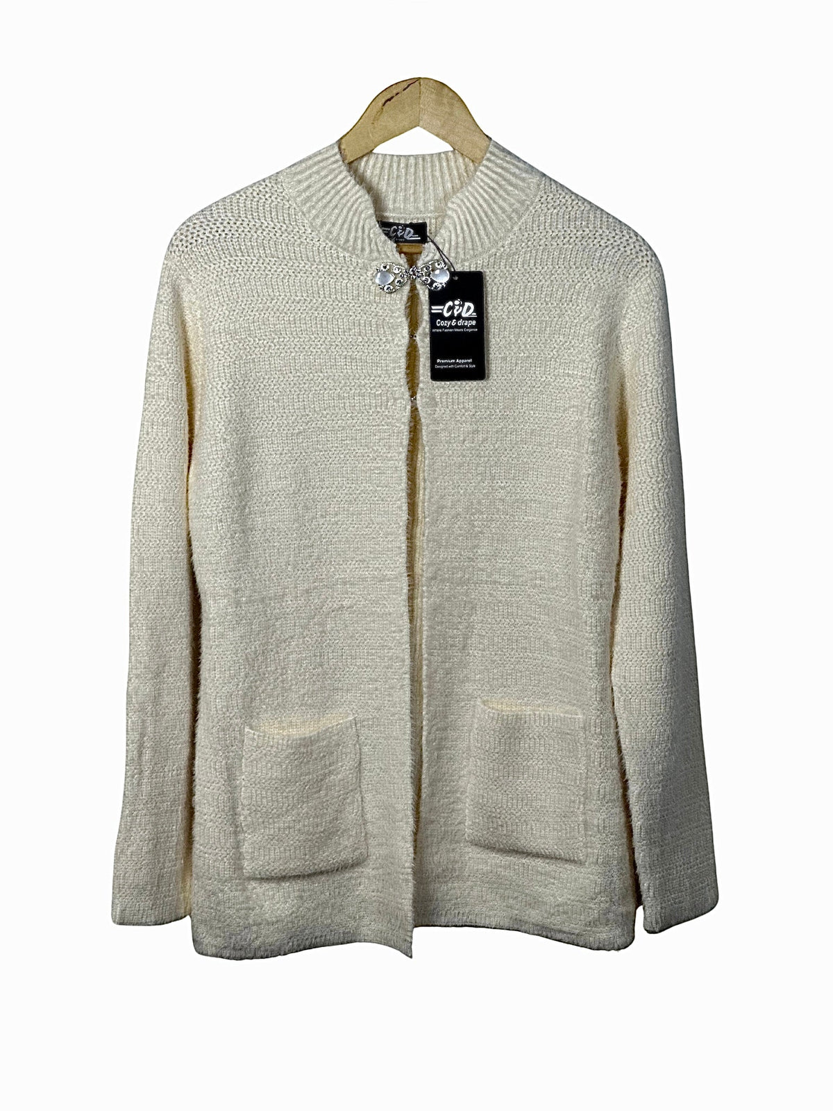 Cozy&Drape cream open-front knit cardigan sweater with long sleeves and two front pockets on a wooden hanger