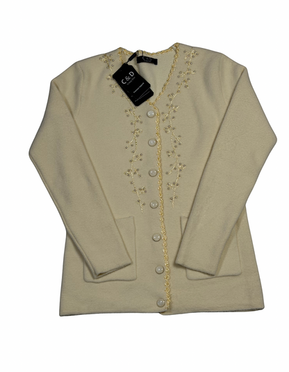 Cozy&Drape cream knit cardigan with V-neck, button front, two pockets, and delicate floral embroidery on the placket.