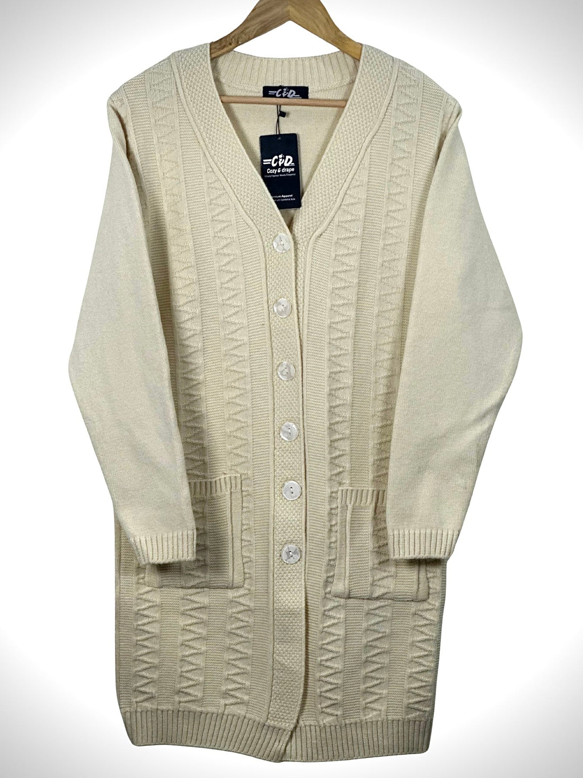 Cozy&Drape cream long-line knit cardigan with a V-neck, button-front closure, and two front pockets on a hanger.