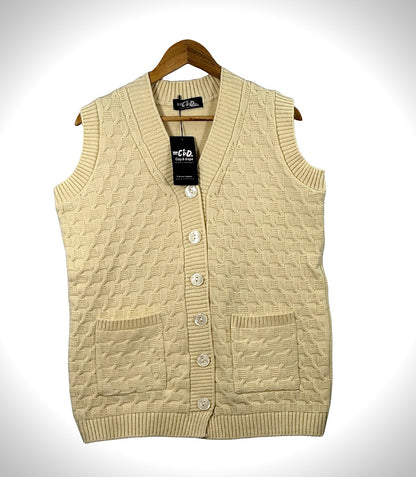 Cozy&Drape sleeveless cardigan sweater in cream with a cable knit pattern, button front, and two front pockets.