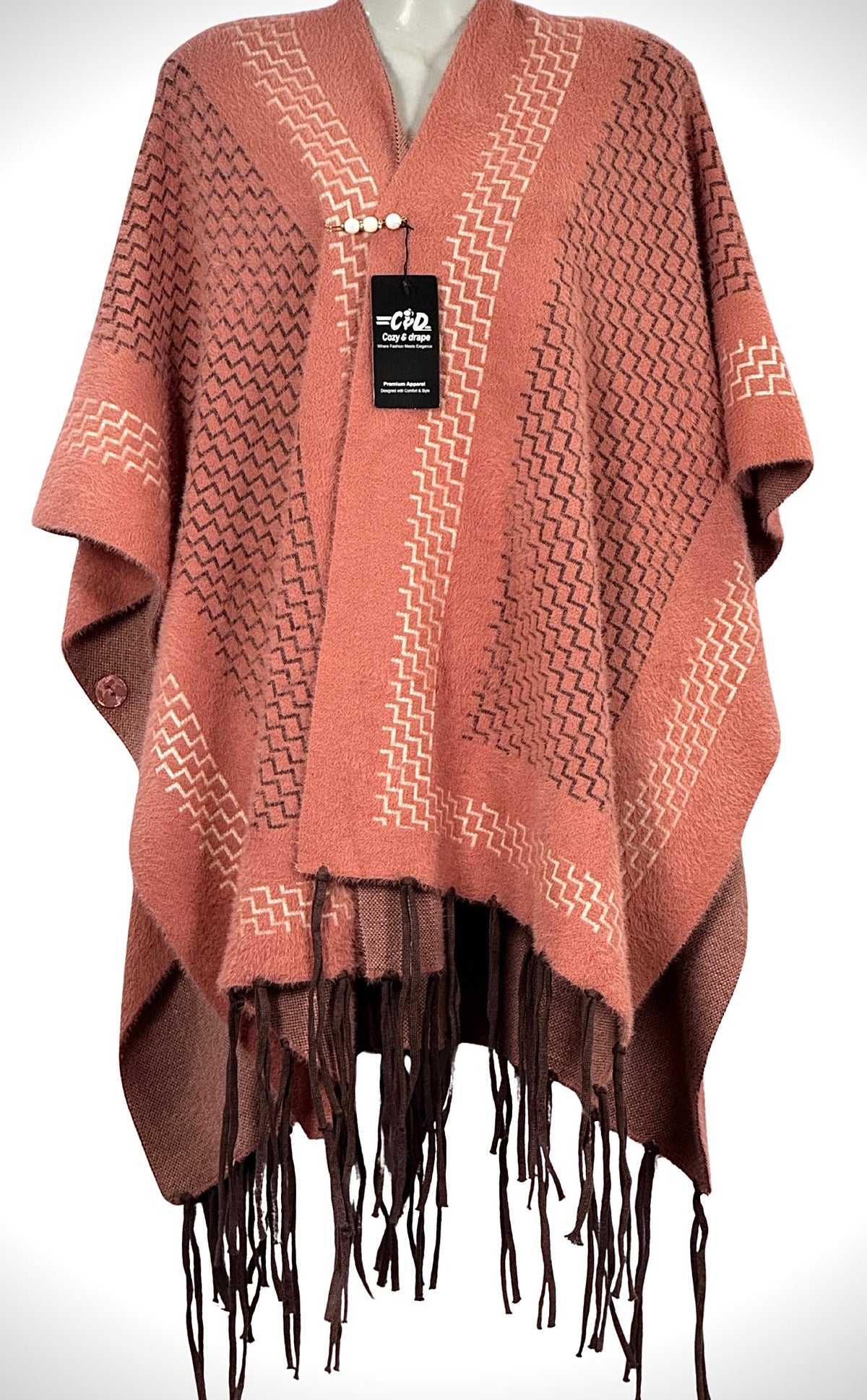 Cozy&Drape winter cape shawl in dusty rose with brown geometric patterns, fringe hem, and button closure.