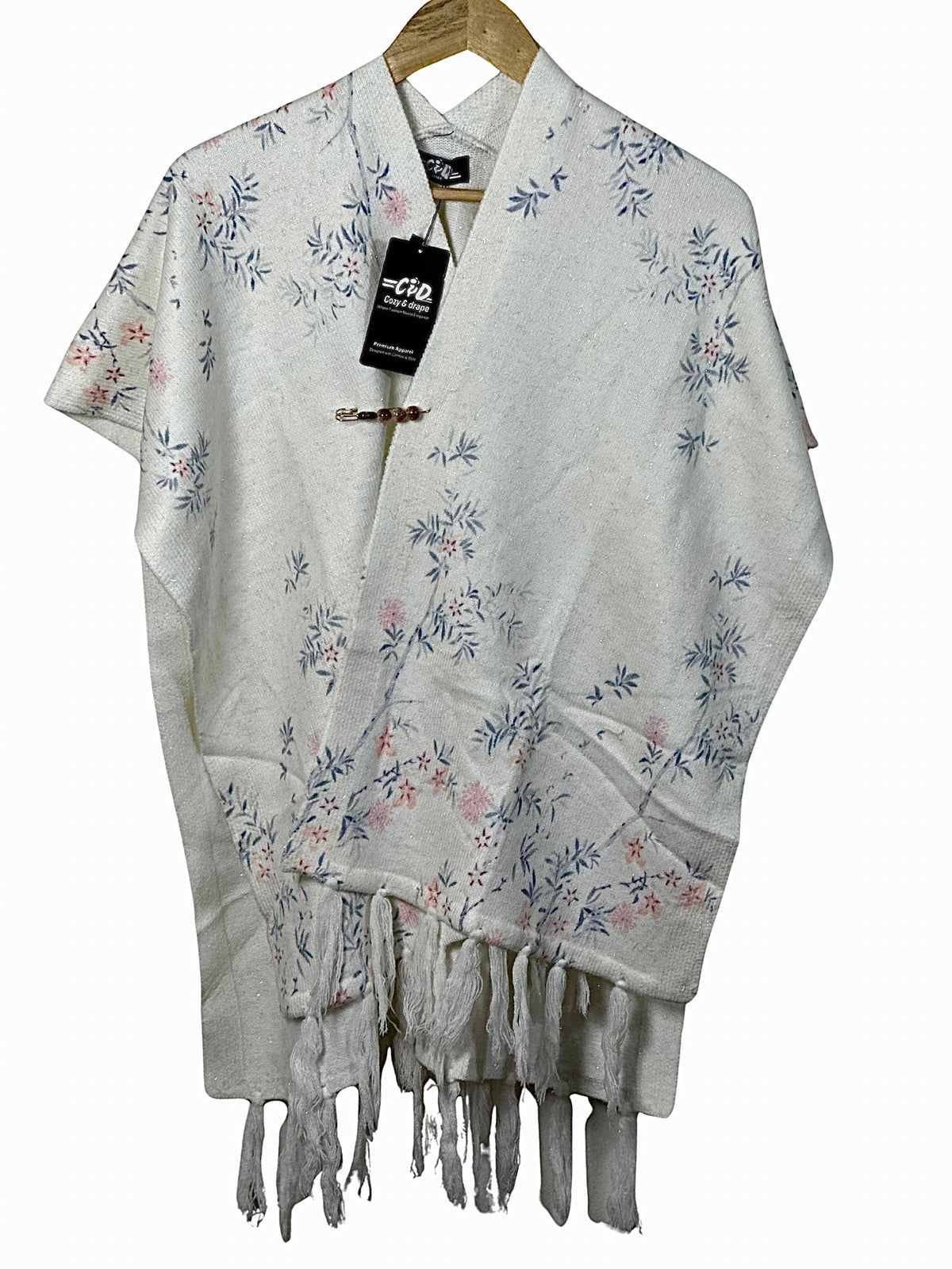 Cozy&Drape white winter cape shawl with delicate blue and pink floral pattern and fringe hem detail