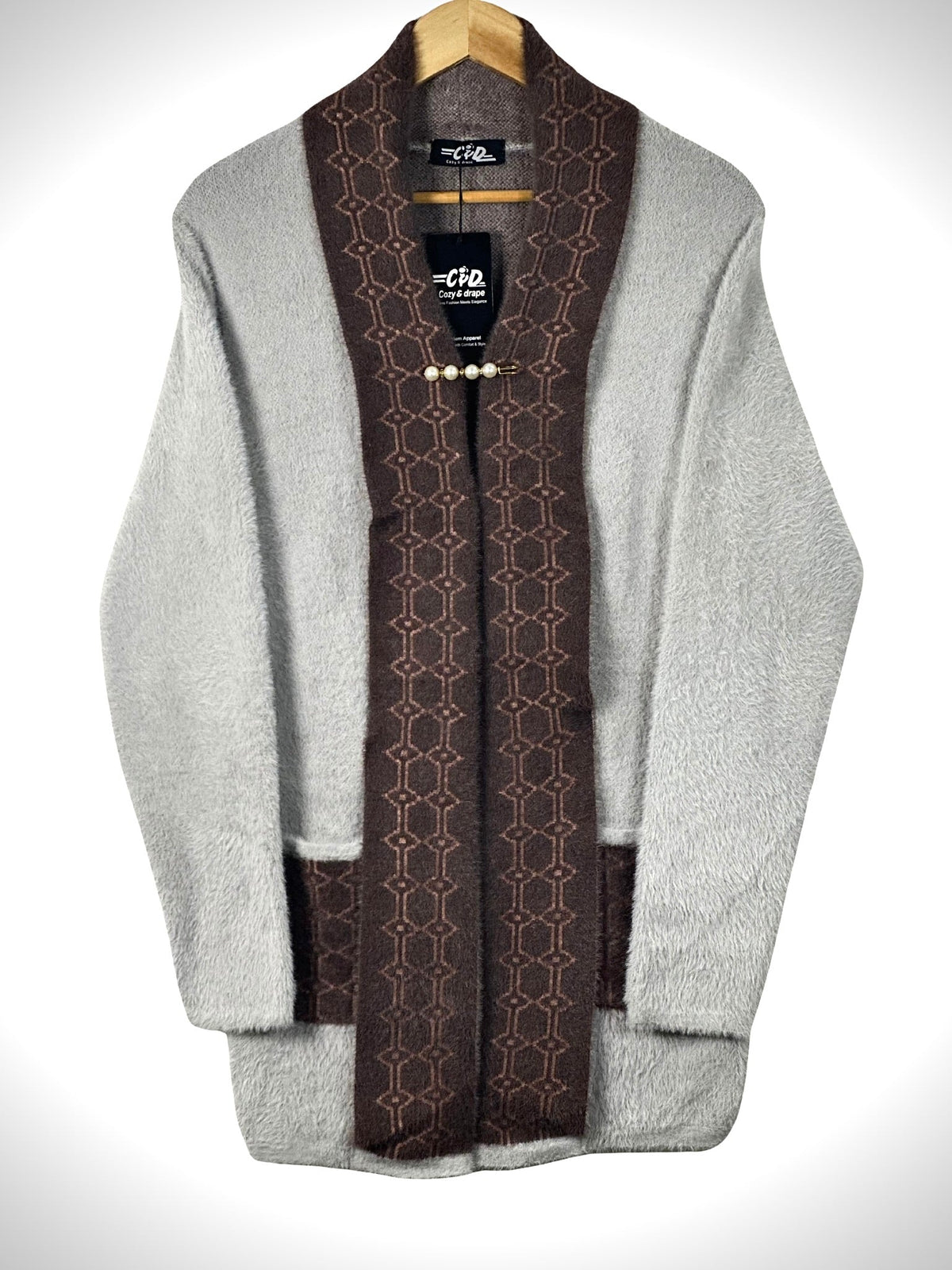 Cozy&Drape open front sweater in grey with brown patterned shawl collar and front pockets on a wooden hanger