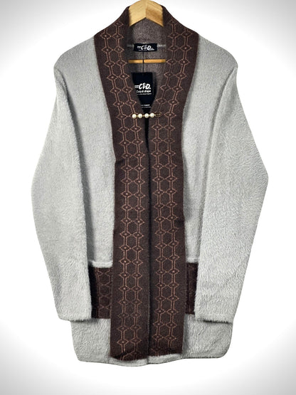 Cozy&Drape open front sweater in grey with brown patterned shawl collar and front pockets on a wooden hanger