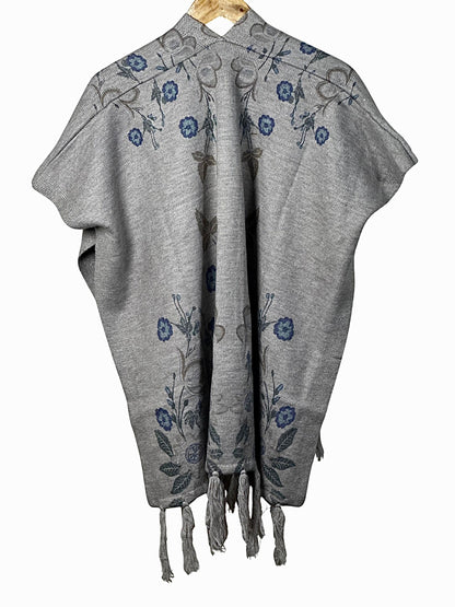 Cozy&Drape grey winter cape shawl featuring elegant blue floral embroidery and decorative tassel hem details.