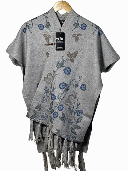 Cozy&Drape grey floral cape shawl with fringe hem and elegant winter design on a wooden hanger