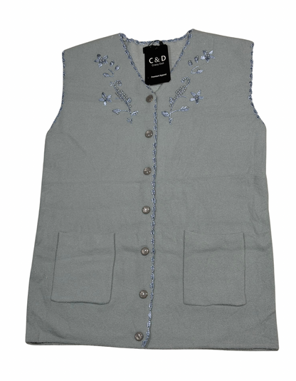 Cozy&Drape sleeveless wool cardigan in grey with floral embroidery, button front, and two patch pockets.