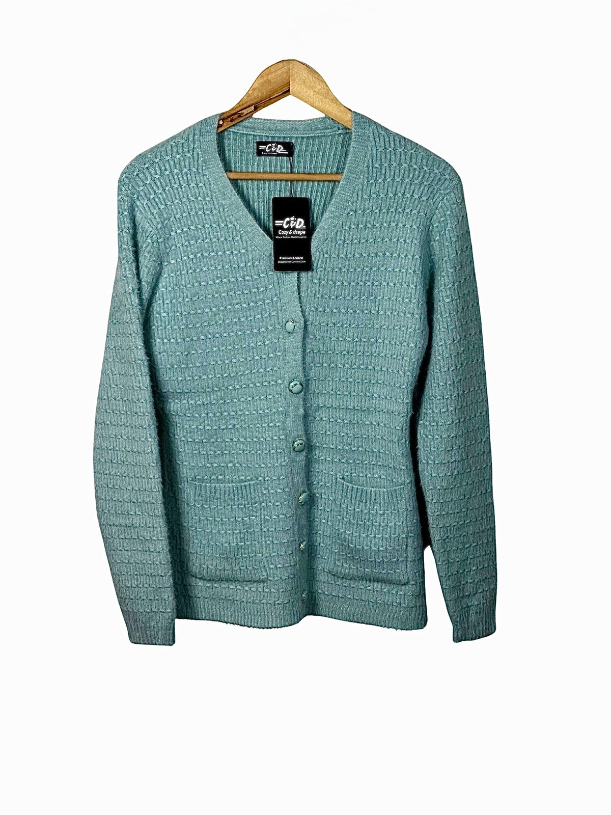Cozy&Drape light blue button-up cardigan sweater with textured knit pattern and front pockets on a wooden hanger