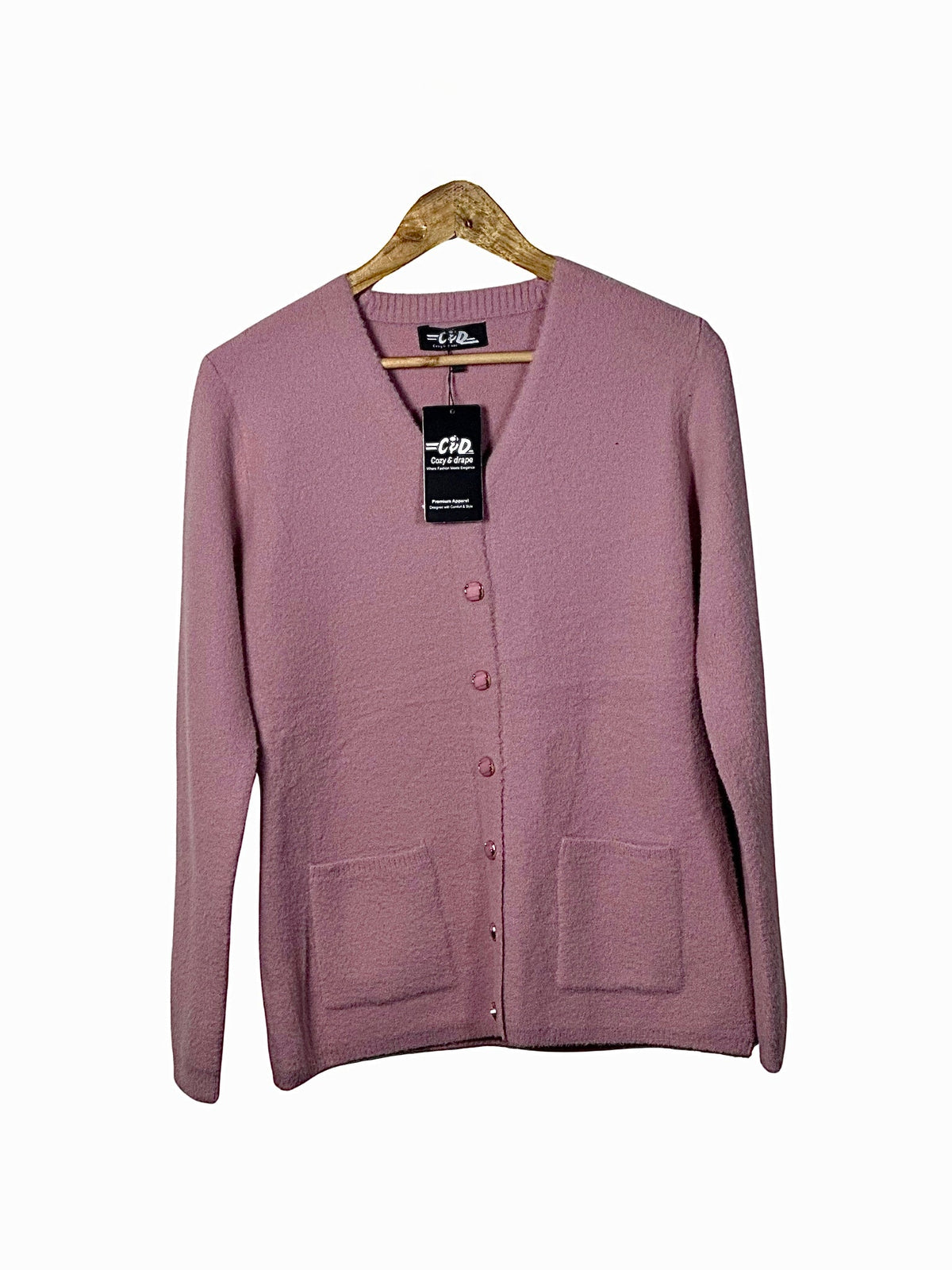Cozy&Drape mauve pink long-sleeve cardigan sweater with front pockets and button-up closure on a wooden hanger