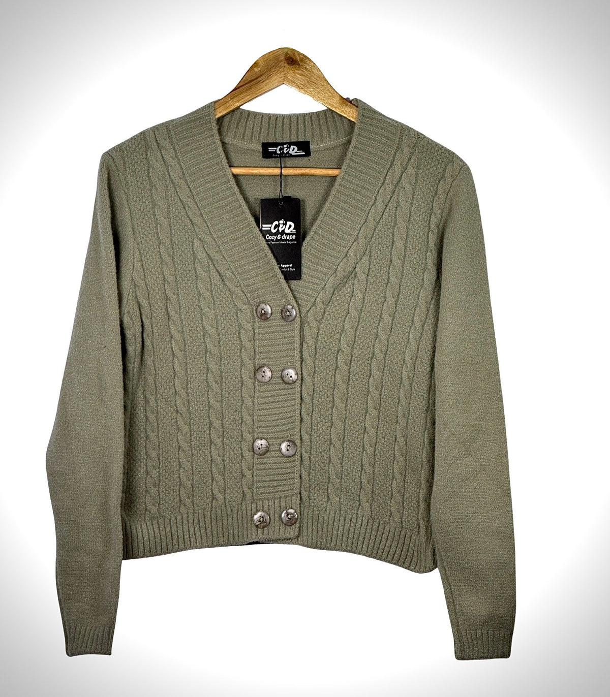 Cozy&Drape olive green cable knit extra short cardigan sweater with a V-neck and button-up front on a wooden hanger