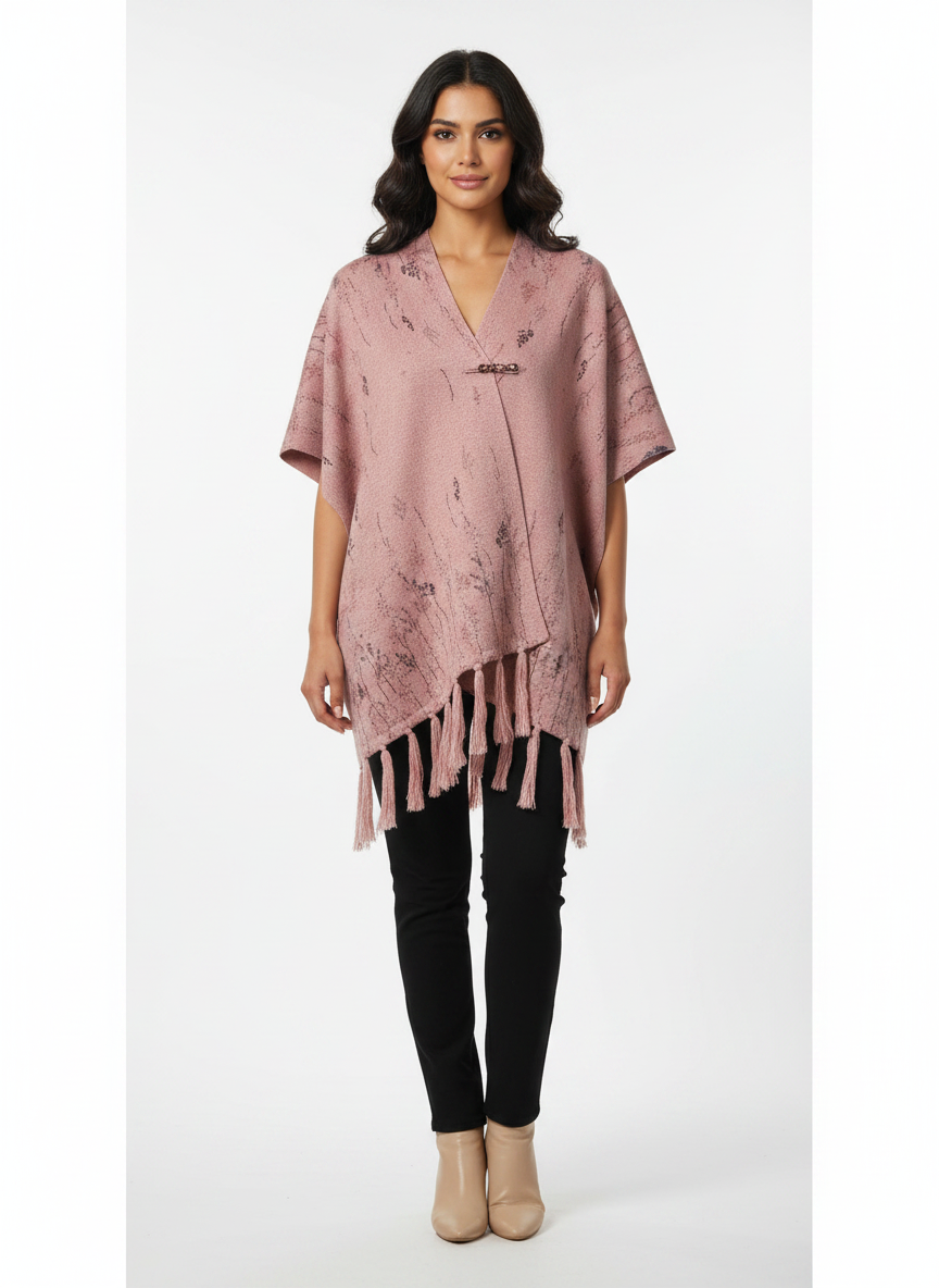 Model wearing a Cozy&Drape dusty pink floral print poncho wrap with fringe hem, side buttons, and a clasp closure.