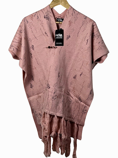 Cozy&Drape dusty pink knit cape shawl with delicate floral patterns, fringe hem, and a decorative toggle closure.