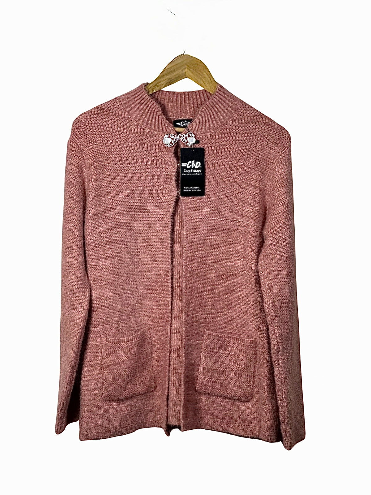 Cozy&Drape pink long-sleeve open cardigan sweater with front pockets and ribbed collar on a wooden hanger