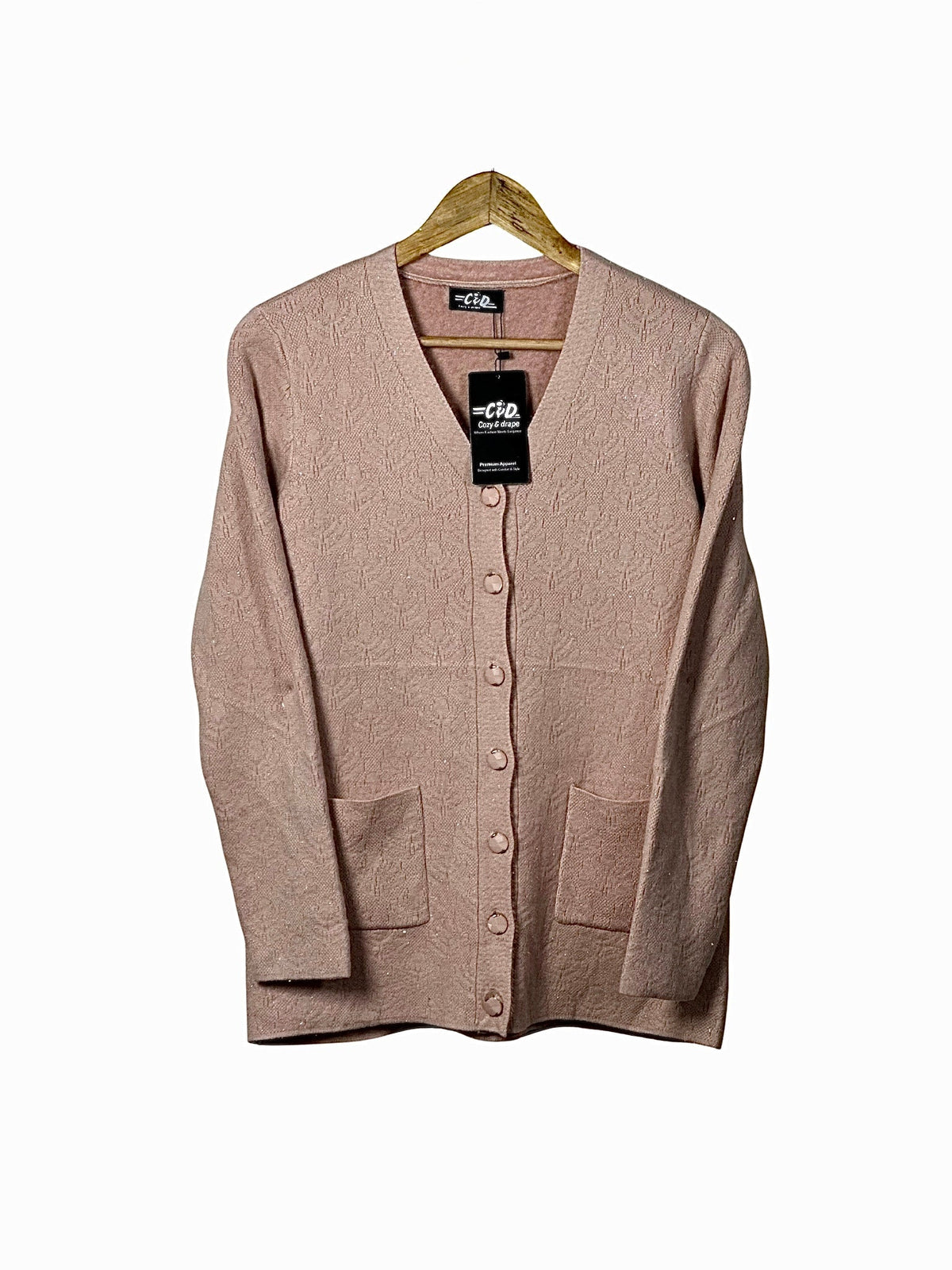 Cozy&Drape blush pink wool cardigan sweater with long sleeves, button front, and two patch pockets on a hanger.
