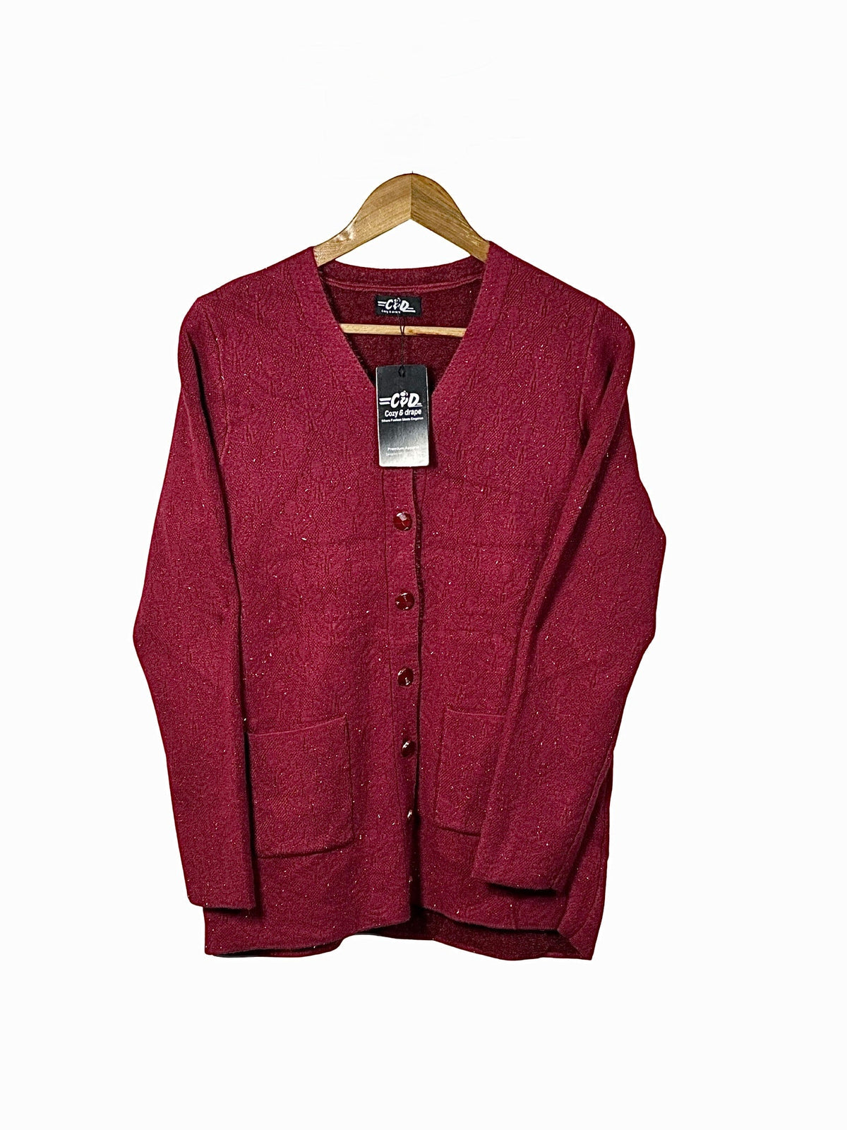 Cozy&Drape burgundy wool cardigan sweater with long sleeves, front buttons, and two pockets on a wooden hanger.