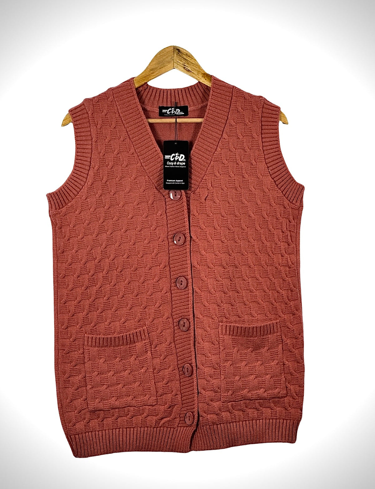 Cozy&Drape sleeveless cardigan sweater in terracotta with cable knit texture, button front, and two patch pockets.