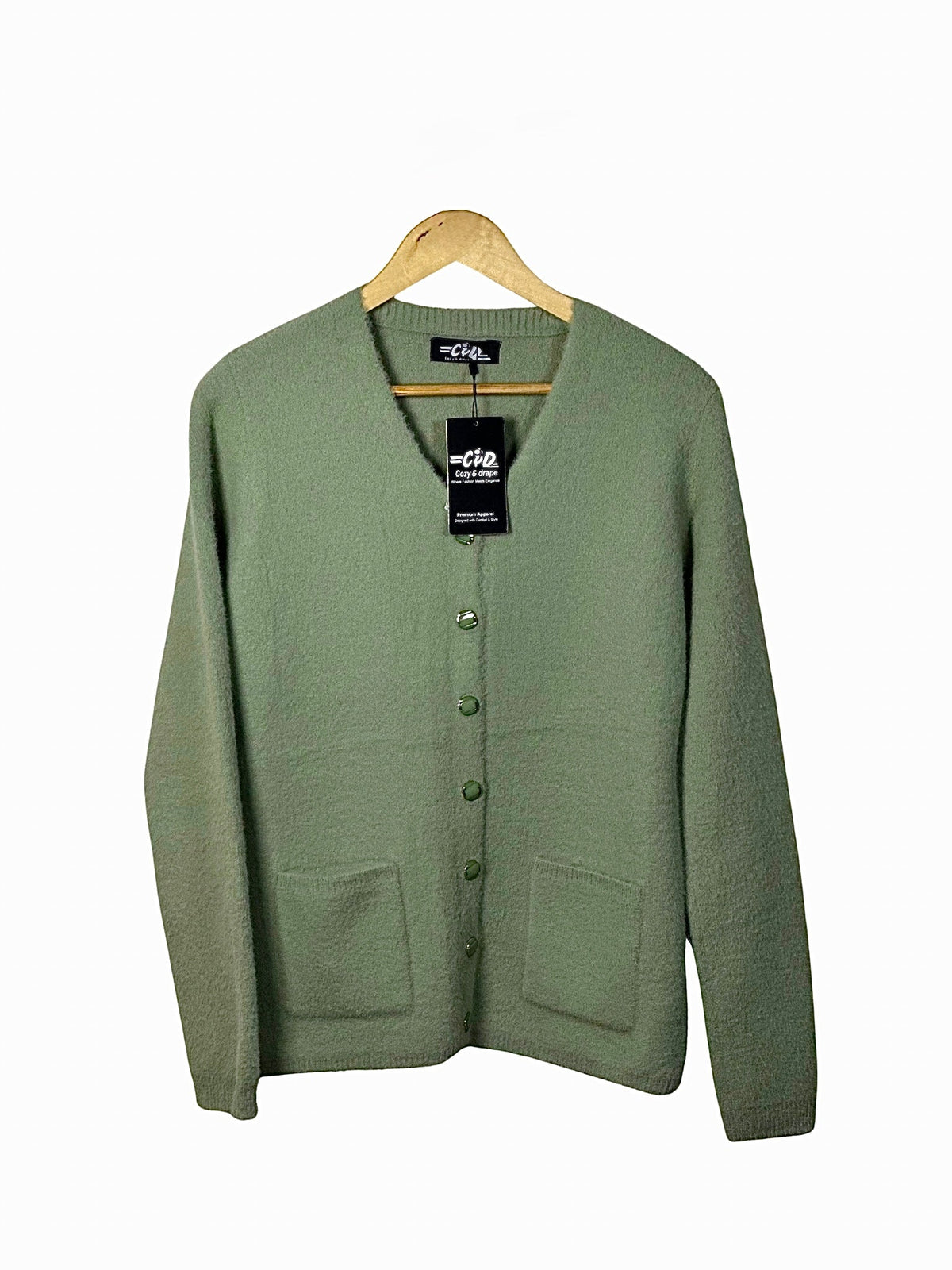 Cozy&Drape sage green button-up cardigan sweater with front pockets and long sleeves on a wooden hanger