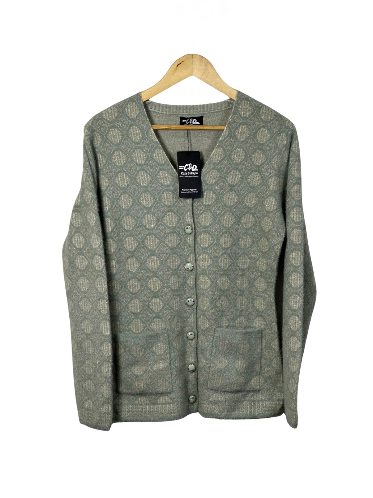 Cozy&Drape sage green patterned button-up cardigan sweater with front pockets hanging on a wooden hanger