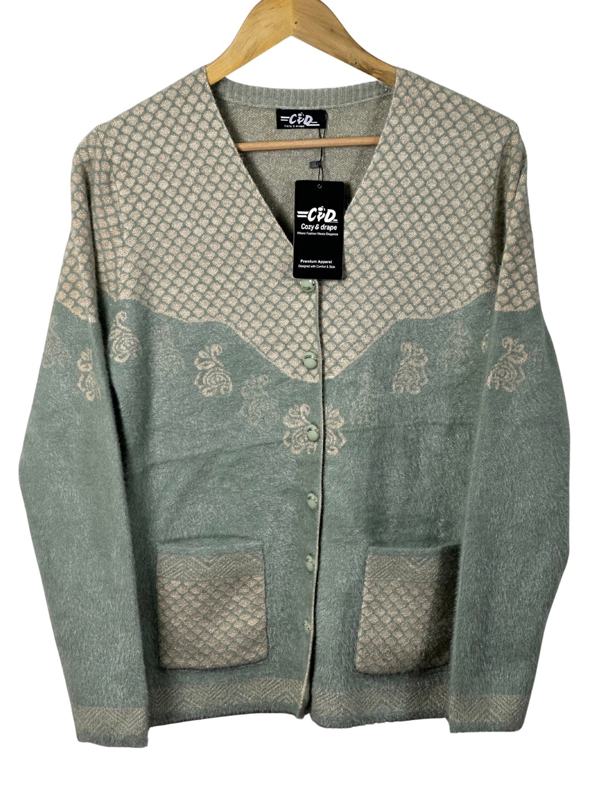 Cozy&Drape sage green and beige patterned knit cardigan with front pockets and button-down closure on a hanger
