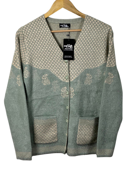 Cozy&Drape sage green and beige patterned knit cardigan with front pockets and button-down closure on a hanger