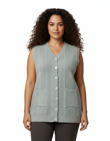 Model wearing a Cozy&Drape sage green sleeveless button-up knit cardigan with a V-neck and front patch pockets.