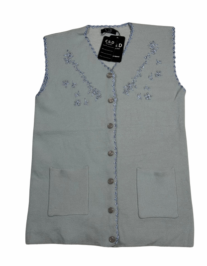 Cozy&Drape sleeveless wool cardigan in light grey with floral embroidery, front buttons, and two patch pockets.