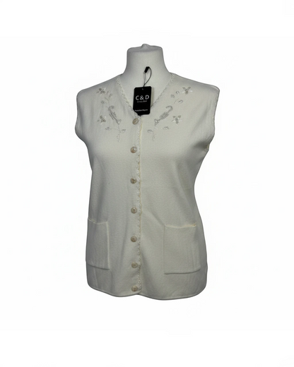 Cozy&Drape sleeveless cream knit cardigan featuring a V-neckline with delicate floral embroidery, beadwork, and pockets