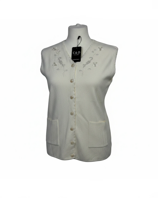 Cozy&Drape sleeveless cream knit cardigan featuring a V-neckline with delicate floral embroidery, beadwork, and pockets