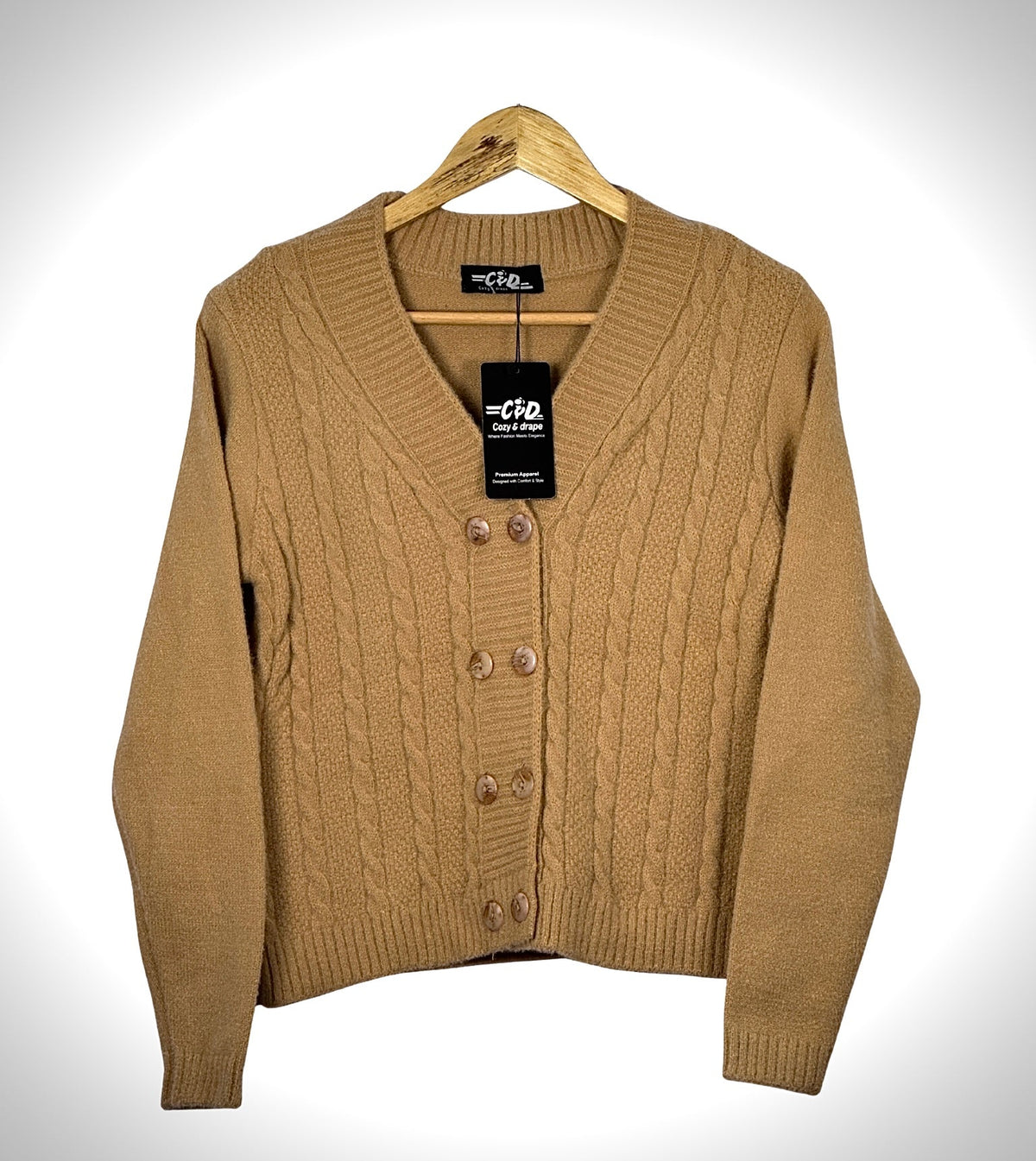 Cozy&Drape tan cable knit extra short cardigan sweater with a V-neck and button-up front on a wooden hanger