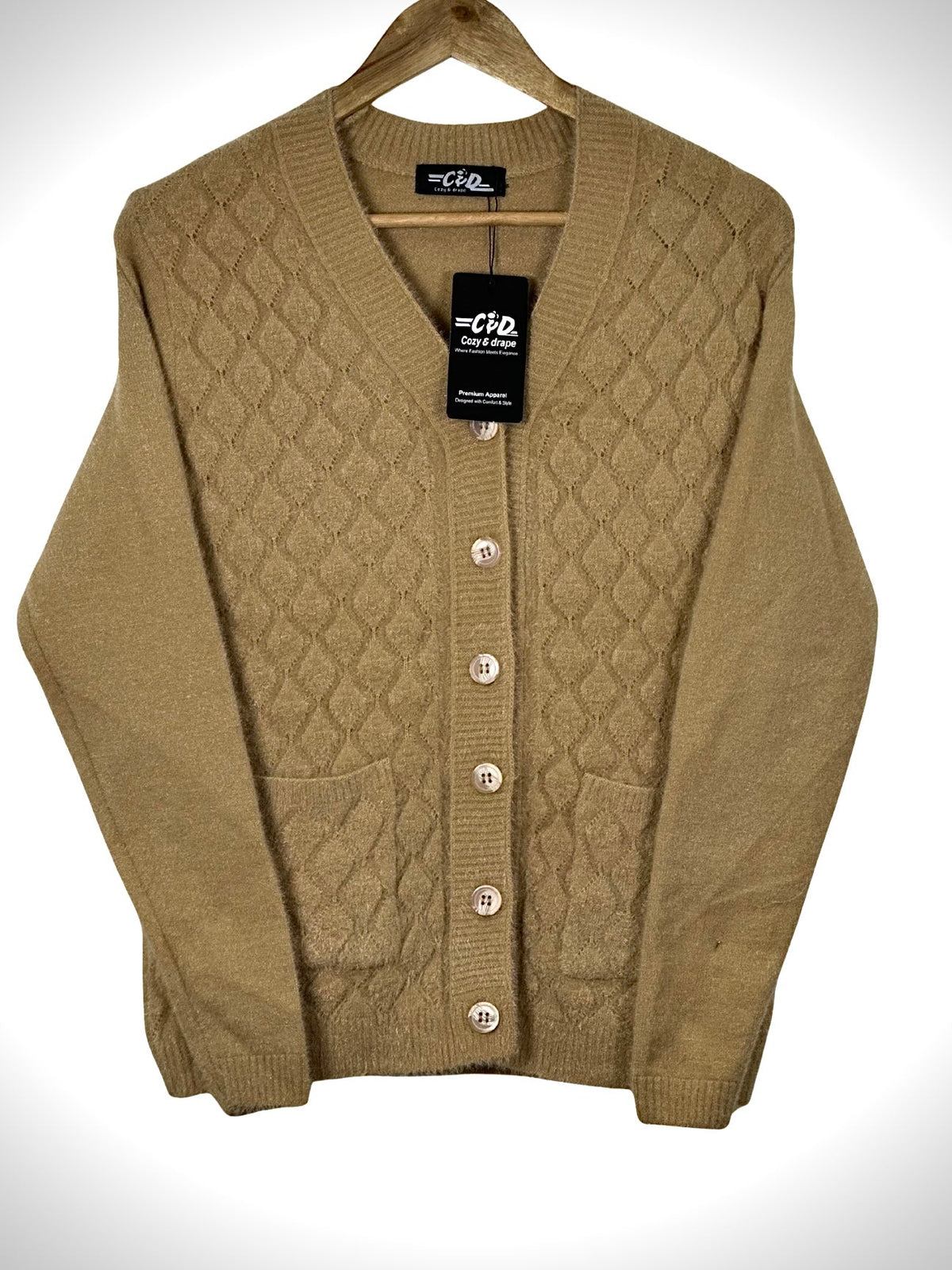 Cozy&Drape tan button-up cardigan sweater with a diamond knit pattern and front pockets on a wooden hanger.