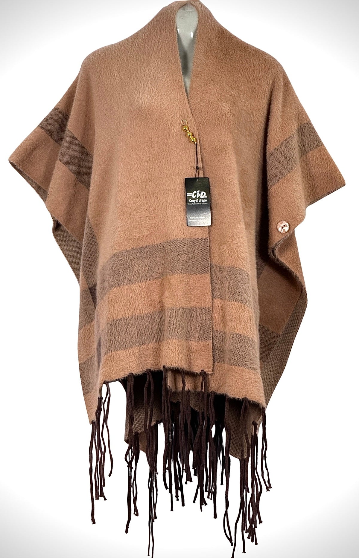 Cozy&Drape beige and brown striped winter cape shawl with fringe hem and button detail on a mannequin