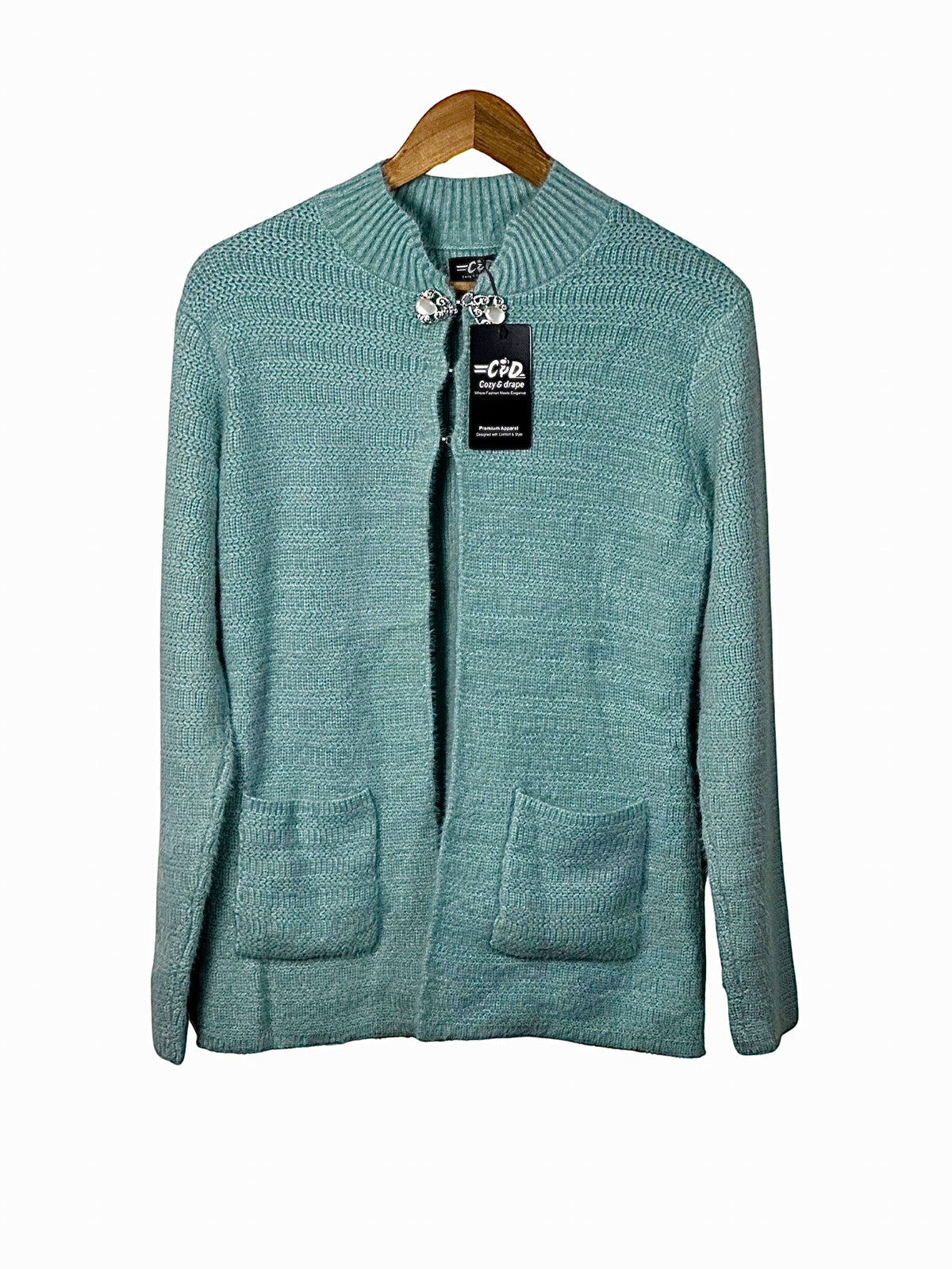 Cozy&Drape teal knit cardigan sweater with long sleeves, ribbed collar, and two front pockets on a wooden hanger